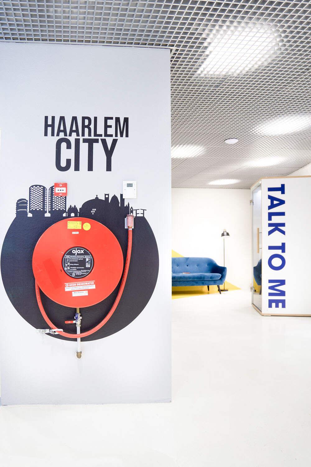 Kantoor sfeer verbeteren door wanddecoratie en belettering met graphic om brandslang.