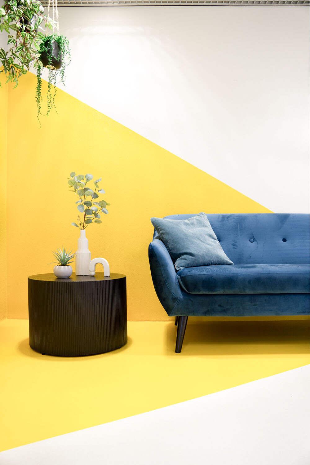 Inspirerende informele loungehoek op industrieel kantoor met moderne wanddecoratie. 