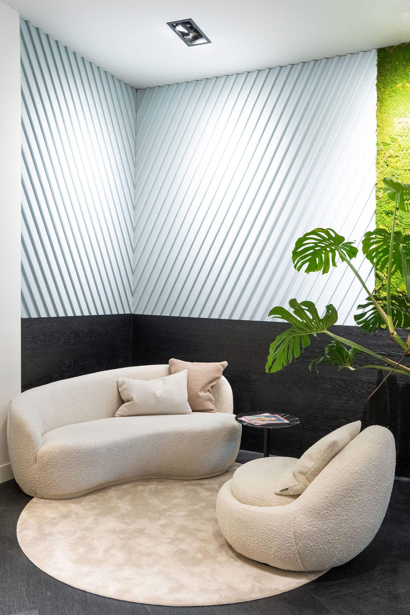 Verbouwing kantoorinrichting van een sfeervolle wachtruimte met grote planten.