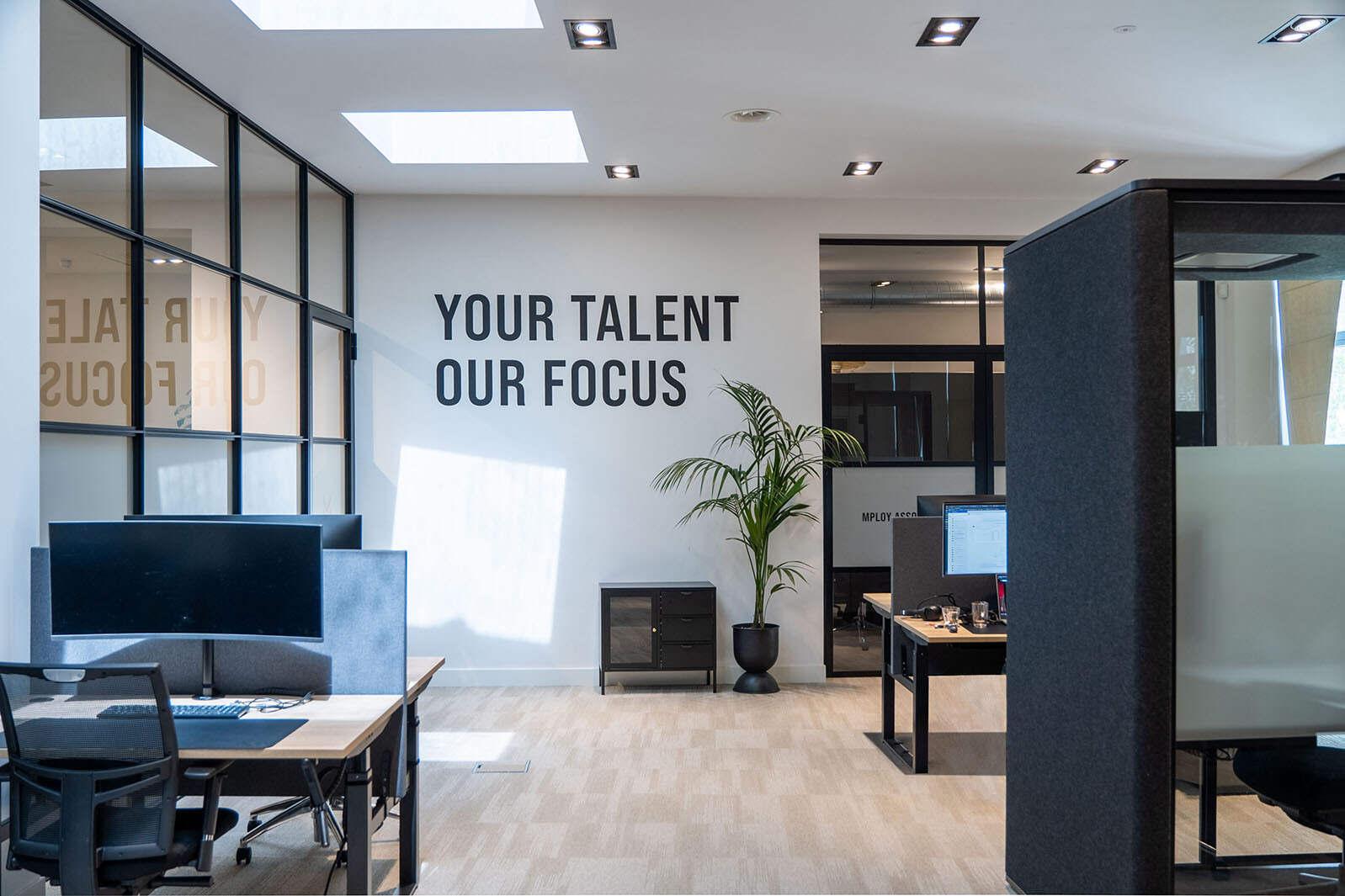 Open kantoorruimte met een concentratie werkplek. Wanddecoratie met inspirerende tekst.