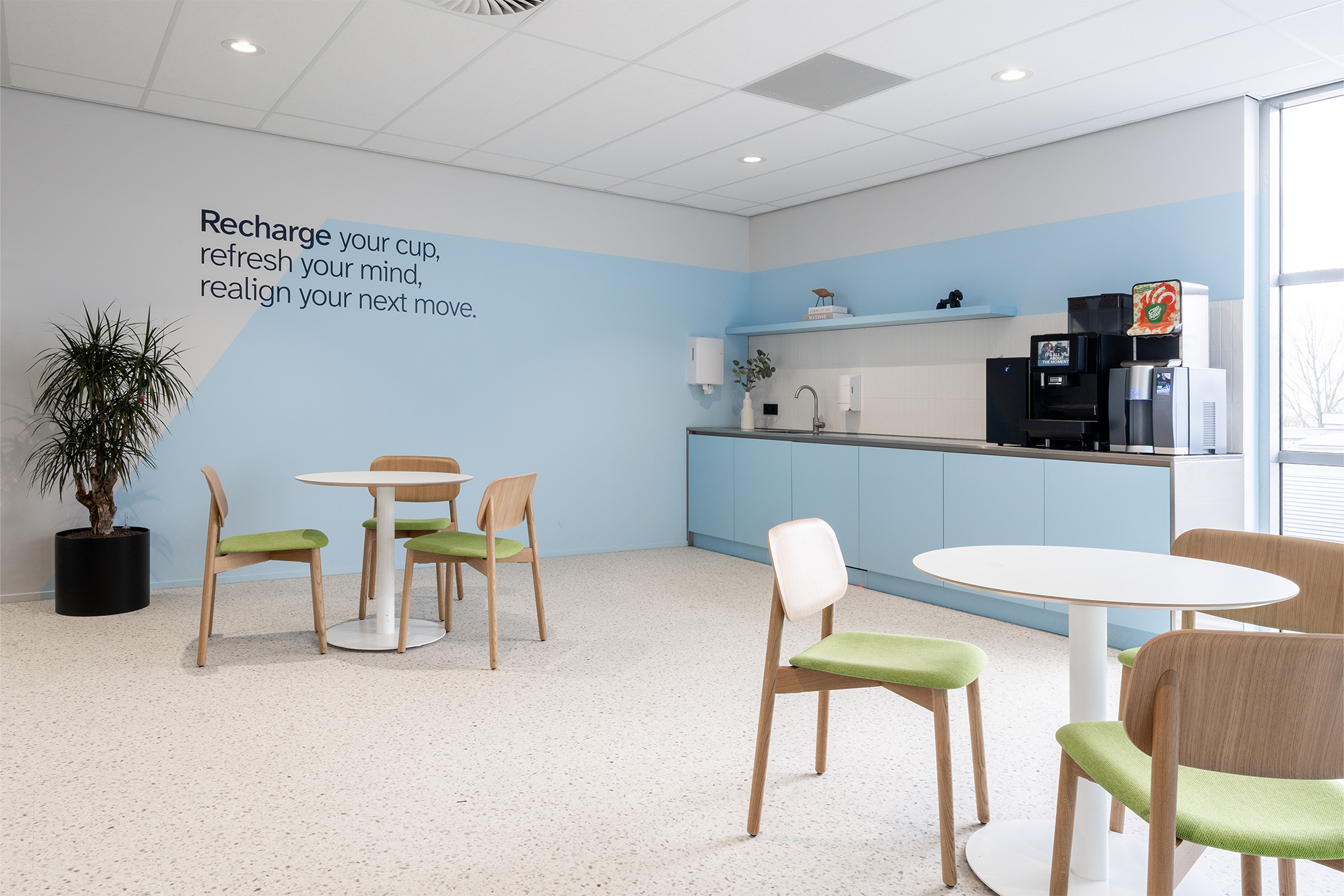 Sociaal ontmoetingspunt in modern kantoorinterieur met comfortabele zitjes, stijlvolle pantry en warme hospitality uitstraling ontworpen voor een inspirerende werkomgeving waar medewerkers samenwerken, ontspannen en verbinden binnen een eigentijdse kantoorinrichting van We are MOSO.